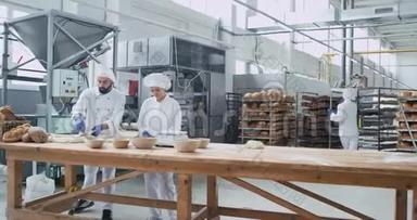 一个大型面包店工业机器面包师在餐桌上制作面包面团时拍摄的大型视频